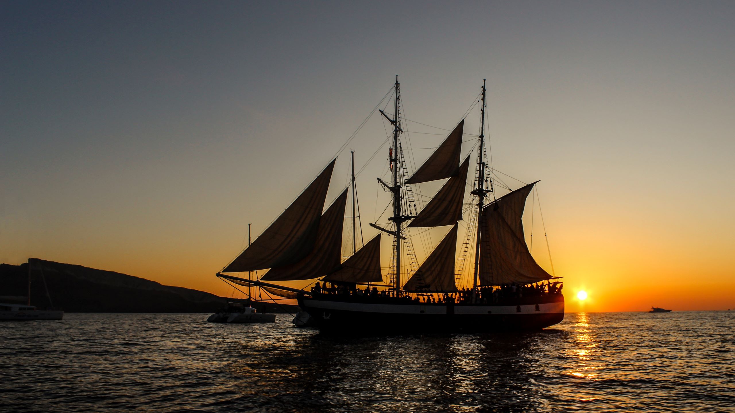 Bild zeigt Segelschiff auf Meer mit Sonnenuntergang